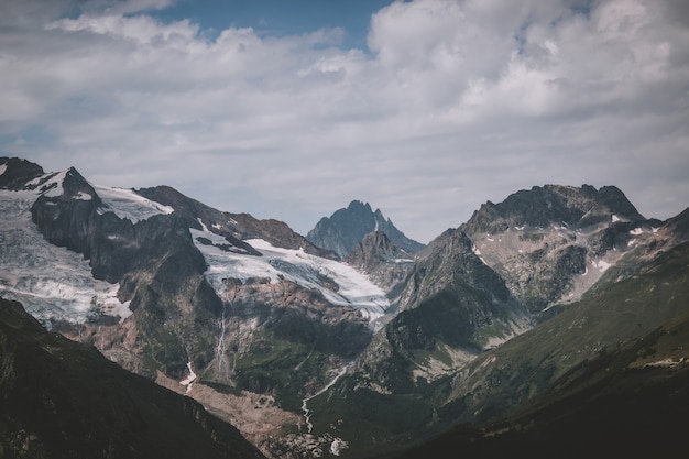 Panorama of mountains scene with dramatic blue sky in national park of Dombay, Caucasus, Russia. Summer landscape and sunny day