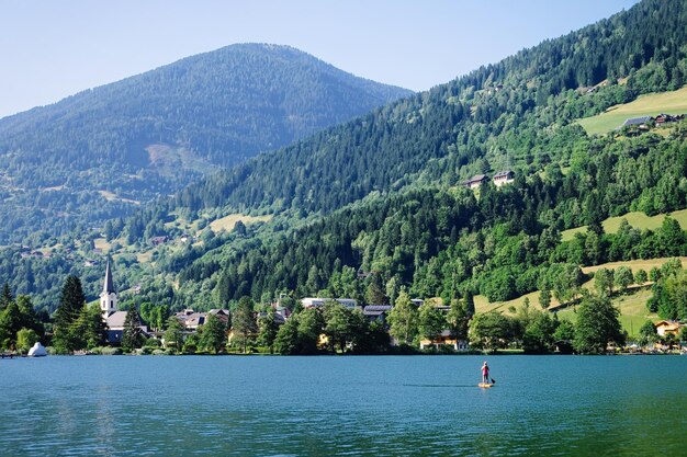 オーストリアのカリンシアにあるフェルトアムゼー湖のパノラマ。春または夏の池と青い空の風景。ヨーロッパの緑のアルプスの風景。アルプス山脈のある田園地帯。水と自然