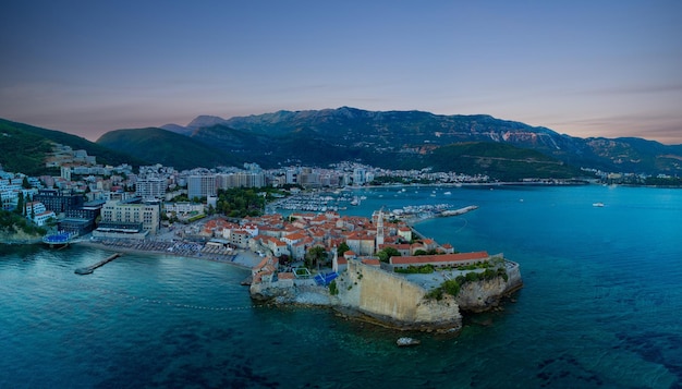 Panorama of port with boats for excursions on the Adriatic Sea near the island of St Stevan in the evening city of Budva