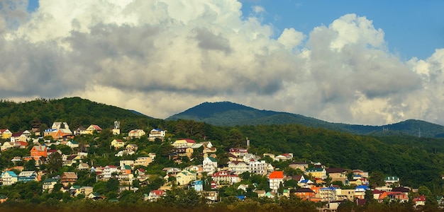 Panorama of a residential area in the mountains against a blue sky with clouds in the evening