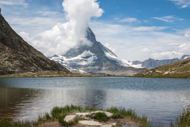 Photo panorama of riffelsee lake and matterhorn mountain, scene in national park zermatt, switzerland, europe. summer landscape, sunshine weather, dramatic blue sky and sunny day