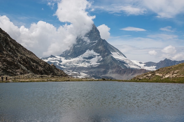 Panorama of Riffelsee lake and Matterhorn mountain, scene in national park Zermatt, Switzerland, Europe. Summer landscape, sunshine weather, dramatic blue sky and sunny day