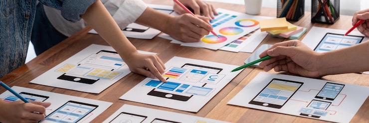 Photo 前端开发团队在纸上为移动应用程序进行 ui 和 ux 设计的全景拍摄 用户界面开发团队为用户友好的 ui 设计进行规划