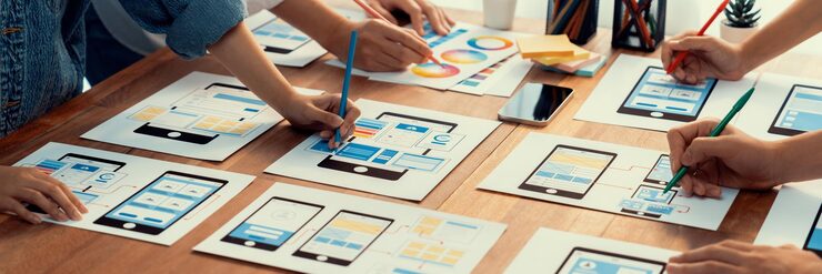 Photo 前端开发团队在纸上为移动应用程序进行 ui 和 ux 设计的全景拍摄 用户界面开发团队为用户友好的 ui 设计进行规划