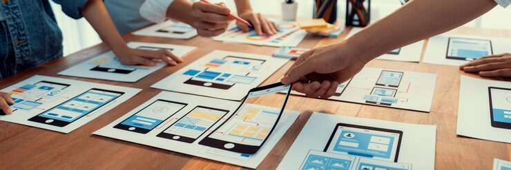 Photo 前端开发团队在纸上为移动应用程序进行 ui 和 ux 设计的全景拍摄 用户界面开发团队为用户友好的 ui 设计进行规划