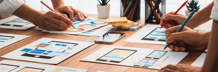 Photo 前端开发团队在纸上为移动应用程序进行 ui 和 ux 设计的全景拍摄 用户界面开发团队为用户友好的 ui 设计进行规划