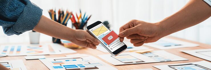 Photo 종이 와이어프레임 인터페이스에서 모바일 앱용 ui 및 ux 디자인을 브레인스토밍하는 프런트엔드 개발자 팀의 파노라마 사진 사용자 친화적인 ui 디자인을 계획하는 사용자 인터페이스 개발 팀