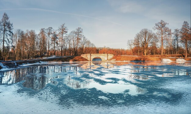 Panorama del parco russo di primavera a gatchina. lo stagno di karpin è ricoperto di pozzanghere e ghiaccio.