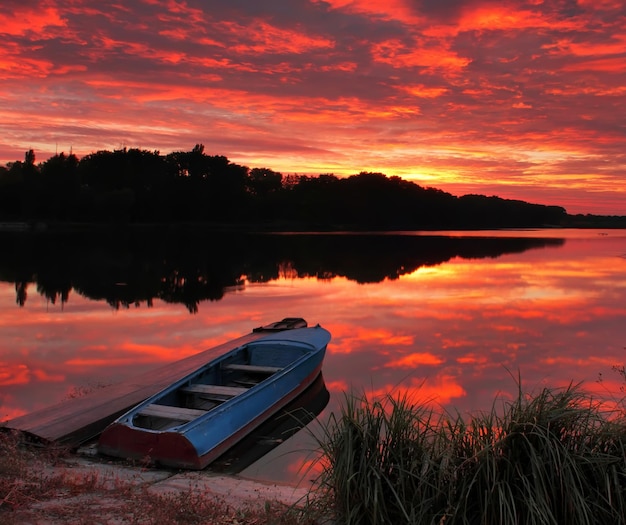 Panorama of sunrise over the lake with a boat