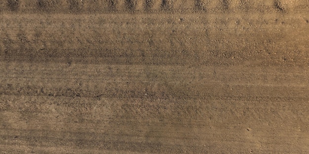 Photo panorama of surface from above of gravel road with car tire tracks