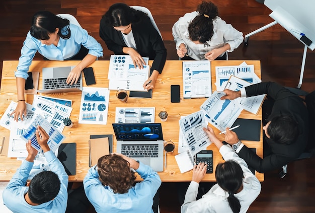 Panorama top view diverse group of business analyst team analyzing financial data report paper on meeting table Chart and graph dashboard by business intelligence analysis Meticulous