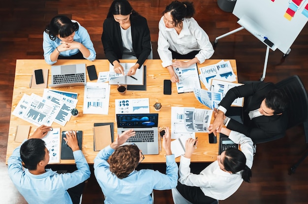 Panorama top view diverse group of business analyst team analyzing financial data report paper on meeting table Chart and graph dashboard by business intelligence analysis Meticulous