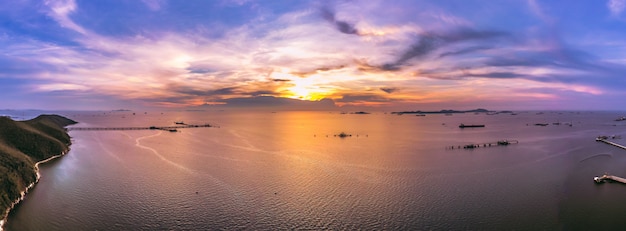 パノラマの夕暮れの風景青い空海の山と船積みの駅石油の上空