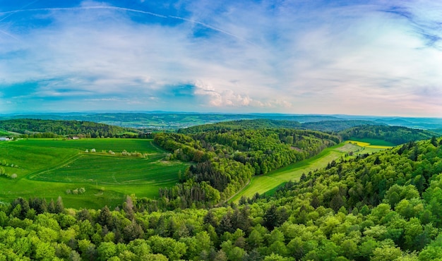 Photo panorama on valley with meadows fields forest and farms against a cloudy sky