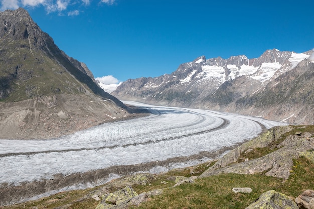 Panorama van de bergenscène, wandeling door de grote Aletsch-gletsjer, route Aletsch Panoramaweg in nationaal park Zwitserland, Europa. Zomerlandschap, zonneschijn, blauwe lucht en zonnige dag