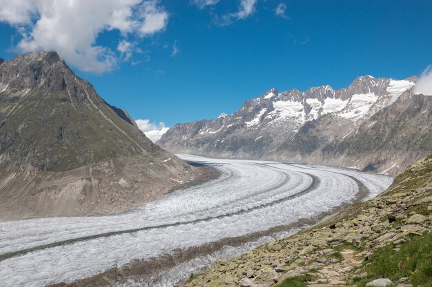 Panorama van de bergenscène, wandeling door de grote Aletsch-gletsjer, route Aletsch Panoramaweg in nationaal park Zwitserland, Europa. Zomerlandschap, zonneschijn, blauwe lucht en zonnige dag