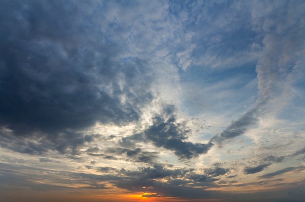 Panorama van de hemel bij zonsopgang of zonsondergang. prachtig uitzicht op donkerblauwe wolken verlicht door fel oranjegele zon op heldere hemel. schoonheid en kracht van de natuur, meteorologie en klimaatveranderend concept.