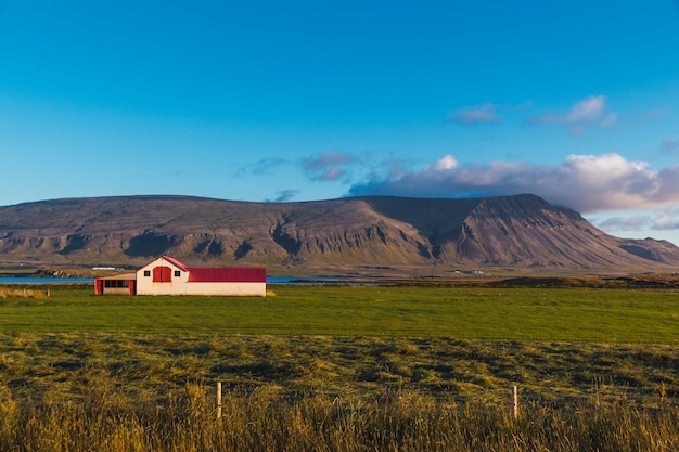 Foto panorama van een vallei met een boerderij in ijsland en enkele bergen