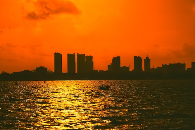 Panorama van het silhouet van de stad Dar es Salaam met wolkenkrabber en kleurrijke lucht over de Indische Oceaan Tanzania