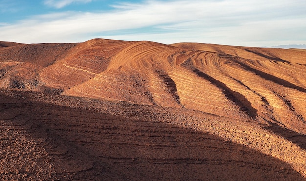 Panorama van heuvels met regelmatig bruin bodempatroon in TizinTinififft pass Ouaourmas Marokko blauwe hemel boven