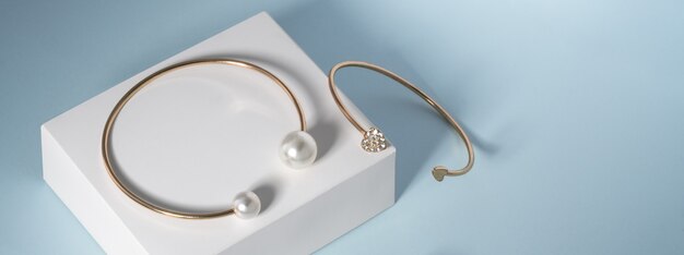 Panorama van Parel gouden armband en diamanten gouden armband op witte en blauwe achtergrond met kopie ruimte