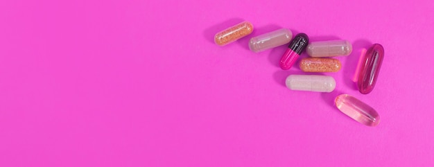 Panorama veelkleurige pillen en capsules op een roze achtergrond
