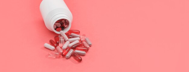 Panorama veelkleurige pillen en capsules op een roze achtergrond