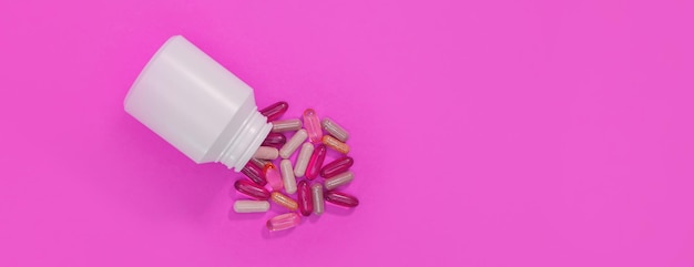 Panorama veelkleurige pillen en capsules op een roze achtergrond