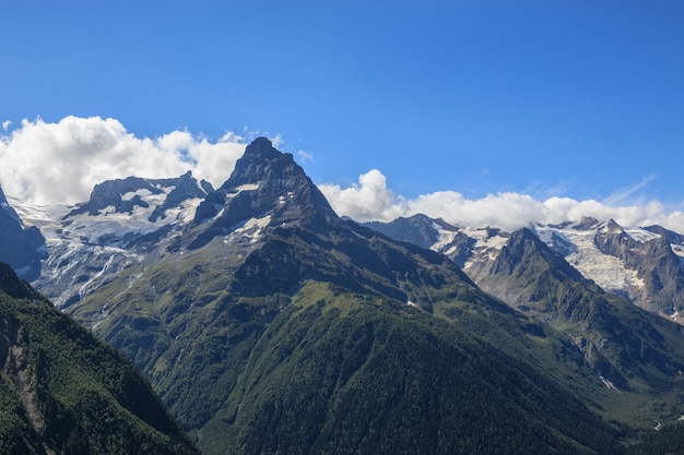 Panorama view of dramatic blue sky and mountains scene in national park Dombay, Caucasus, Russia. Summer landscape and sunny day