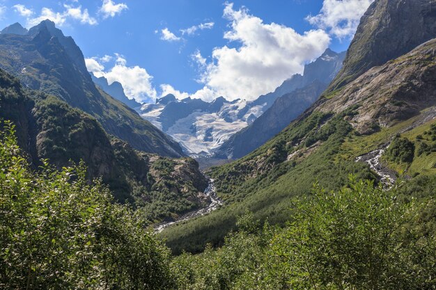 Panorama view of mountains scene in national park of Dombay, Caucasus, Russia. Summer landscape, sunshine weather, dramatic blue sky and sunny day