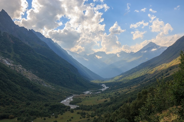 Panorama view on mountains with river scene in national park of Dombay, Caucasus, Russia. Summer landscape, sunshine weather and sunny day