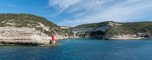 Panorama of the yacht to the lighthouse rocks blue sky with small clouds horizontal orientation