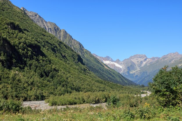 Panoramamening van bergenscènes in nationaal park Dombay, Kaukasus, Rusland, Europa. Zomerlandschapsdag en zonnige blauwe lucht