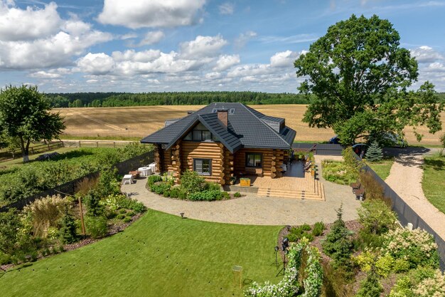 Panoramic aerial view of eco village with wooden houses gravel road gardens and orchards