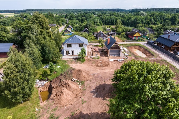 Фото Панорамный воздушный вид эко-деревни с деревянными домами, гравийными дорогами, садами и фруктовыми садами