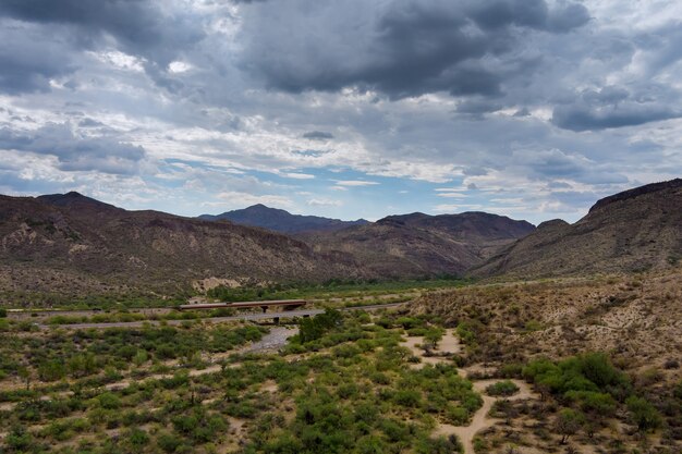 Panoramic aerial view with dramatic clouds over the mountains is a desert cactus mountain landscape near the highway in Arizona of America