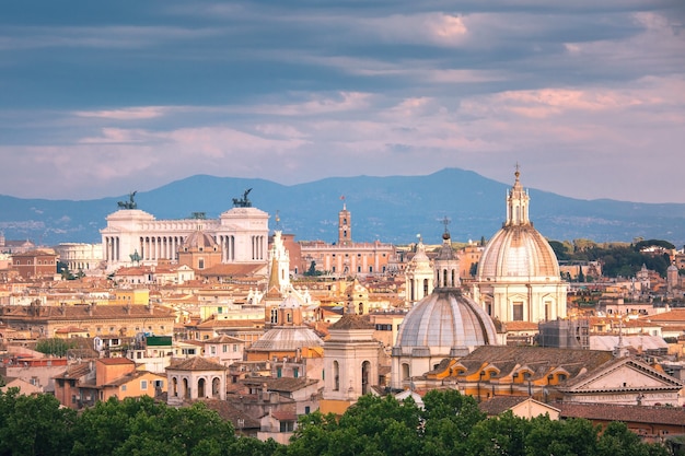 Panoramic aerial wonderful view of Rome with Altar of the Fatherland and churches at sunset time in Rome, Italy