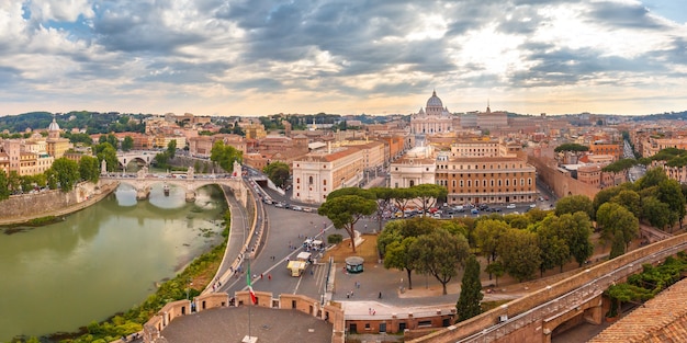 Panoramic aerial wonderful view of Rome with river Tiber and Saint Peter Cathedral at sunset time in Rome, Italy