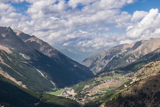 Photo panoramic alpine gorge green slopes hiker's path village clouds cogne aosta valley italy