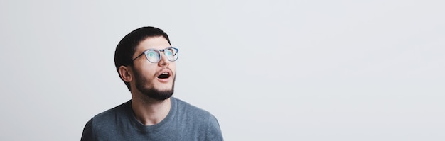 Panoramic banner portrait of young shocked guy with round eyeglasses