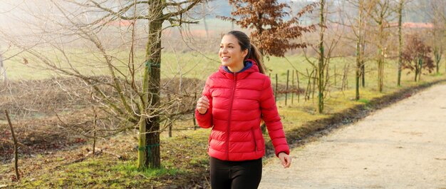 Photo panoramic banner view of young woman running in fall autumn