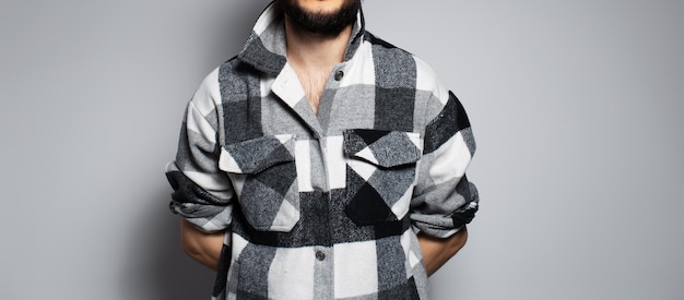 Photo panoramic banner young man dressed in black and white plaid shirt on grey