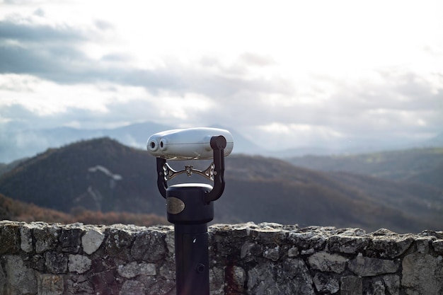 Panoramic binoculars on a terrace overlooking the green hills