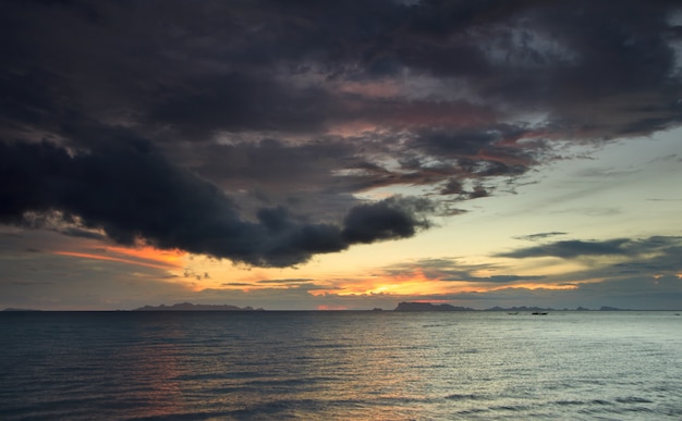 パノラマの劇的な熱帯の海の夕日と雲の雨の背景