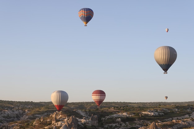 Panoramic image of hot air balloons flying in clear blue sky travel tourism and extreme