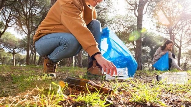 Panoramic image of young women cleaning forest plastic garbage\
horizontal banner environmental activist concept