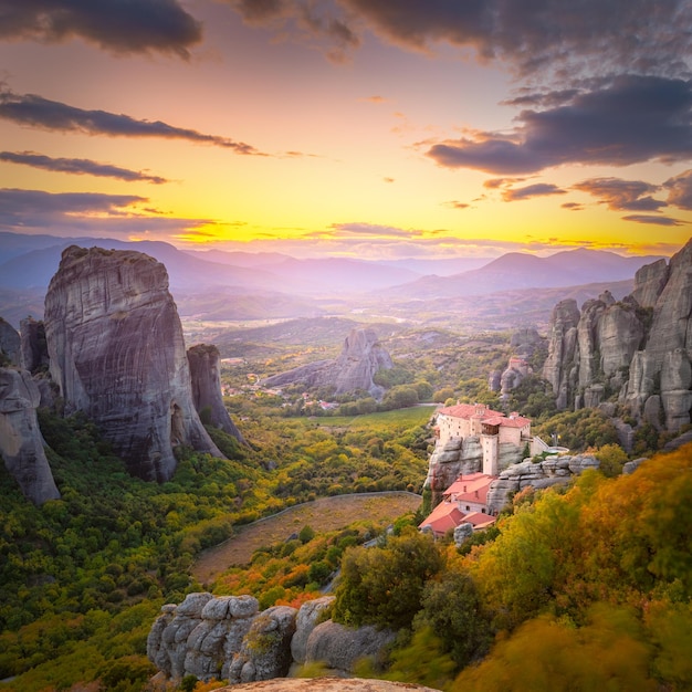 Photo panoramic landscape of meteora greece at romantic sundown time with real sun and sunset sky meteora incredible sandstone rock formations the meteora area is on unesco world heritage greece