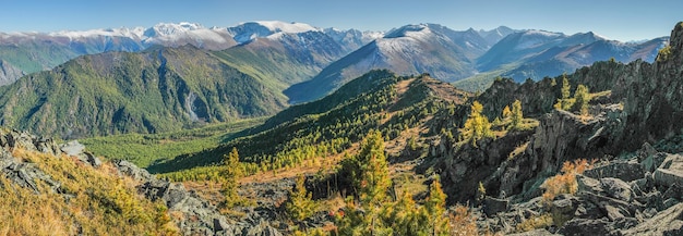 Panoramic mountain view forested slopes snowcapped peaks autumn