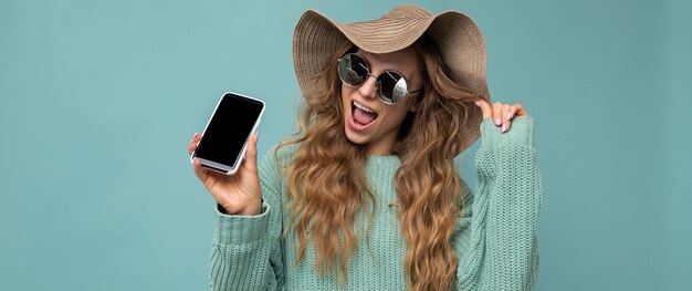 Panoramic photo of beautiful happy young blonde woman wearing sunglasses and summer hat isolated on