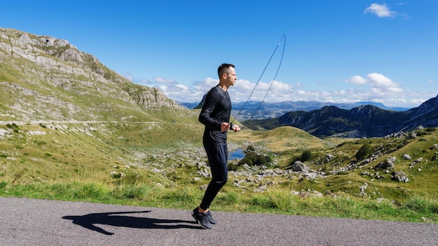 Panoramic photo of a man training against the background of mountains Summer training outside